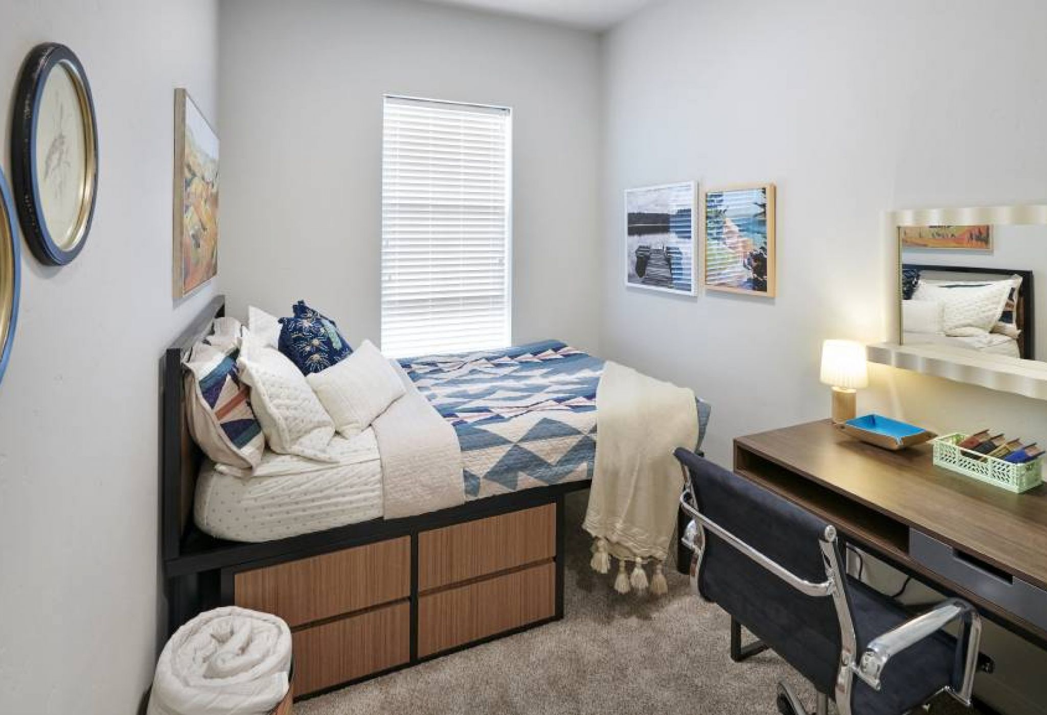 A second bedroom in VERVE Boise featuring a twin bed with under-bed storage, a desk, and vibrant wall art, creating a cozy, functional space.