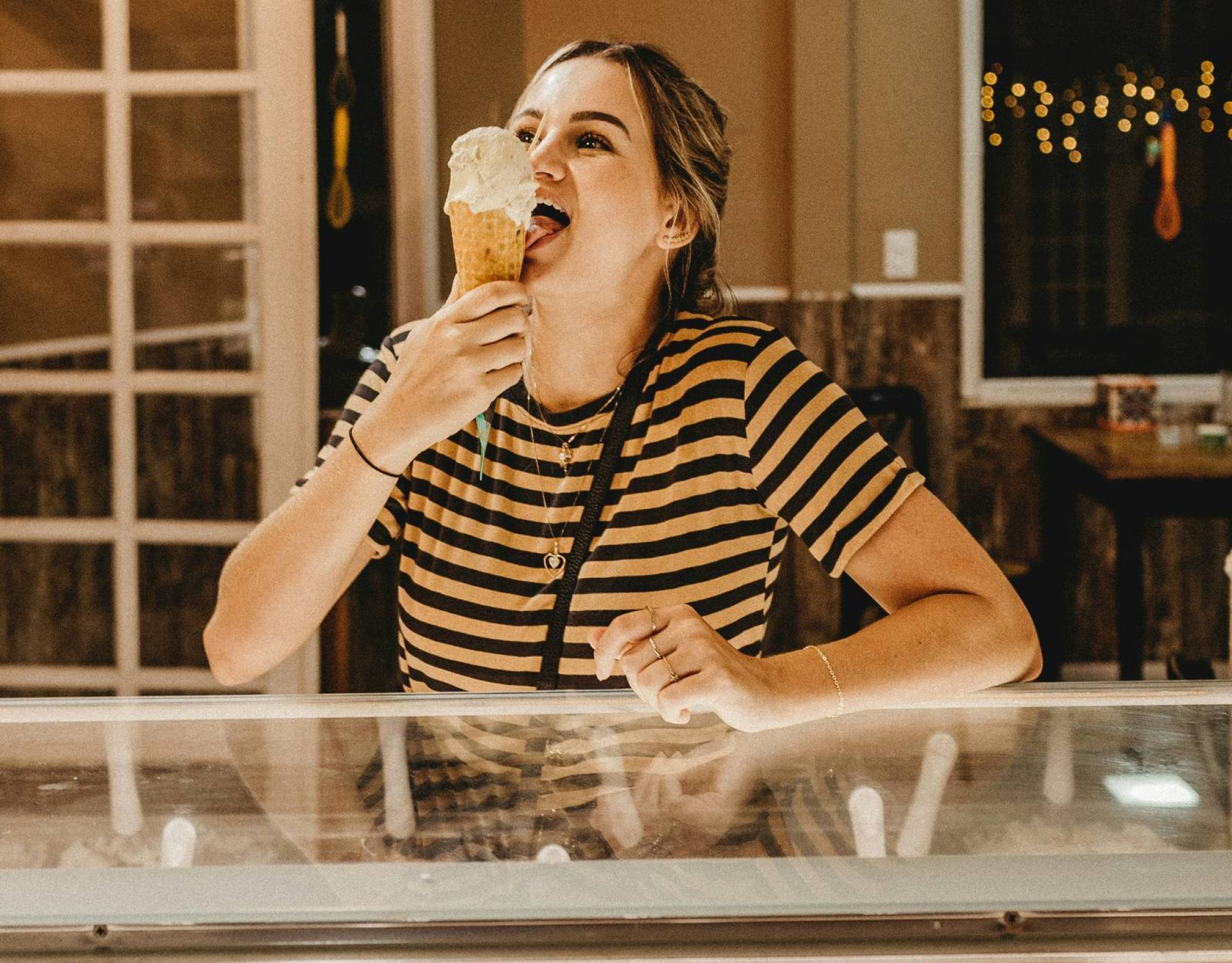 Woman eating ice cream cone in ice cream shop
