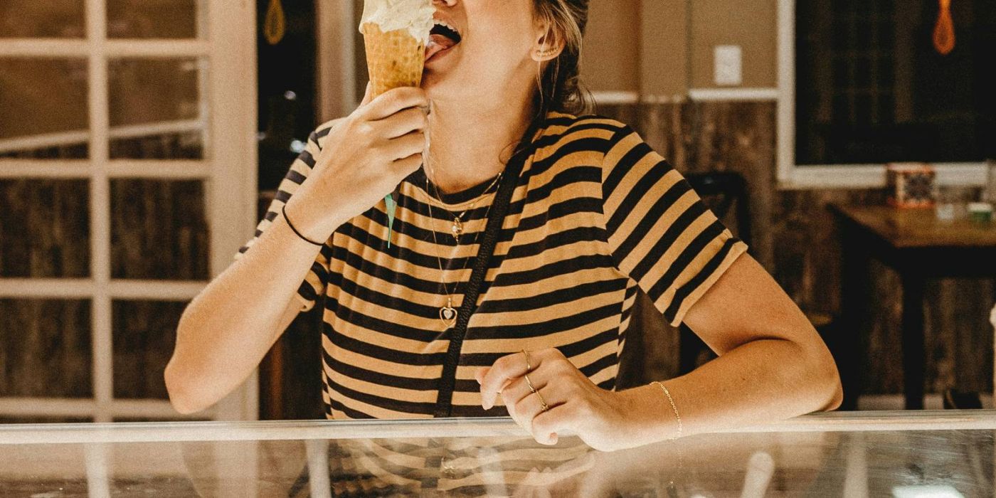 Woman eating ice cream cone in ice cream shop