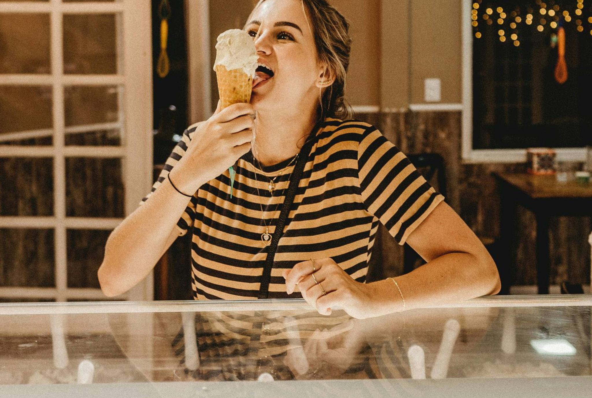 Woman eating ice cream cone in ice cream shop